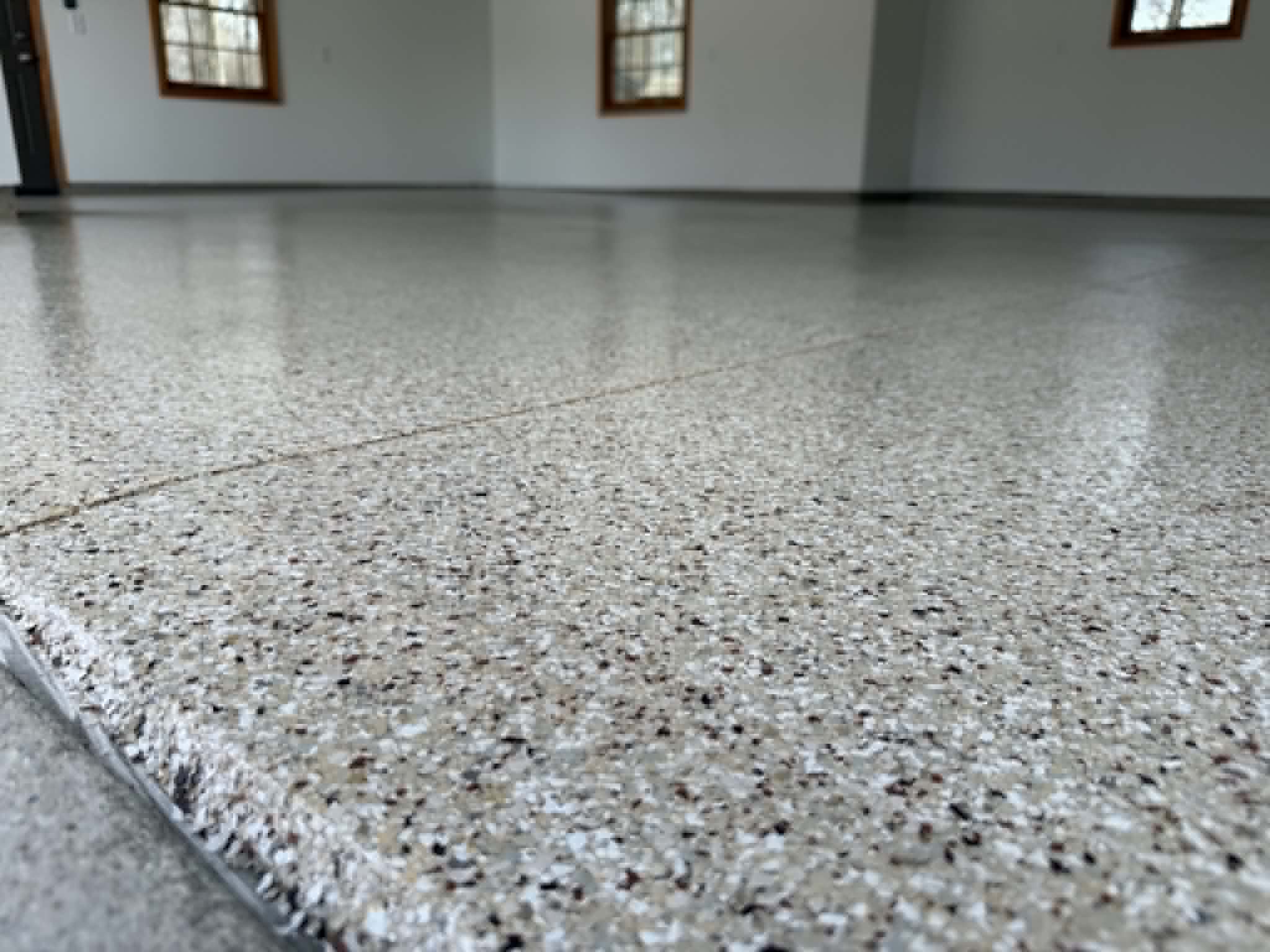 Northwoods Coatings crew applying garage epoxy to residential garage floor in Sheboygan Wisconsin